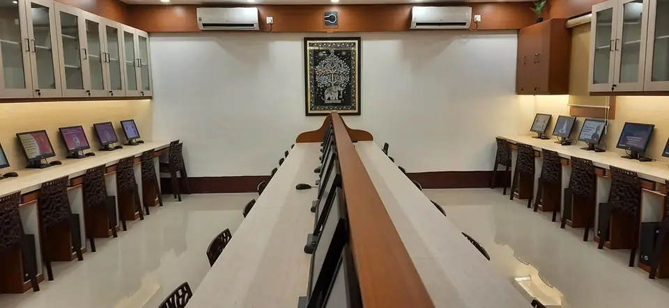 Duvar kenarlarındaki masalarda sıralanmış bilgisayarların bulunduğu boş bir salon